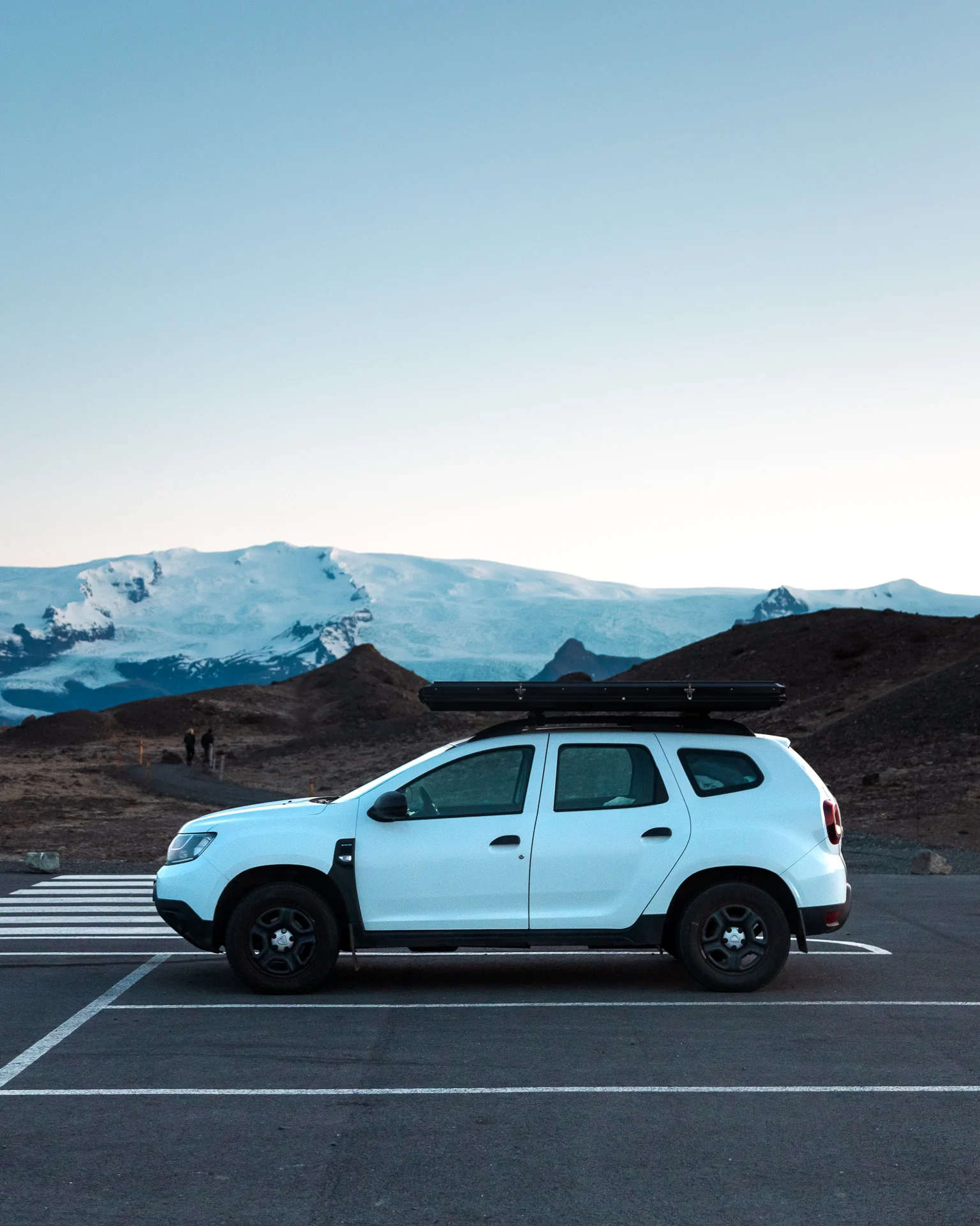 Weißer Dacia Duster vor isländischen Bergen